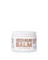 Sun balm jar with white lid on a light beige background